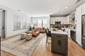 A modern kitchen with a dining area and a living room.